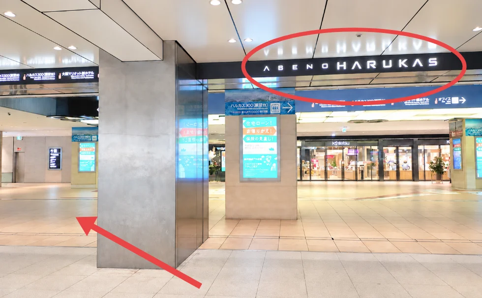 「近鉄電車」の案内表示に従って進んだ先に見えるあべのハルカス近鉄本店の入口