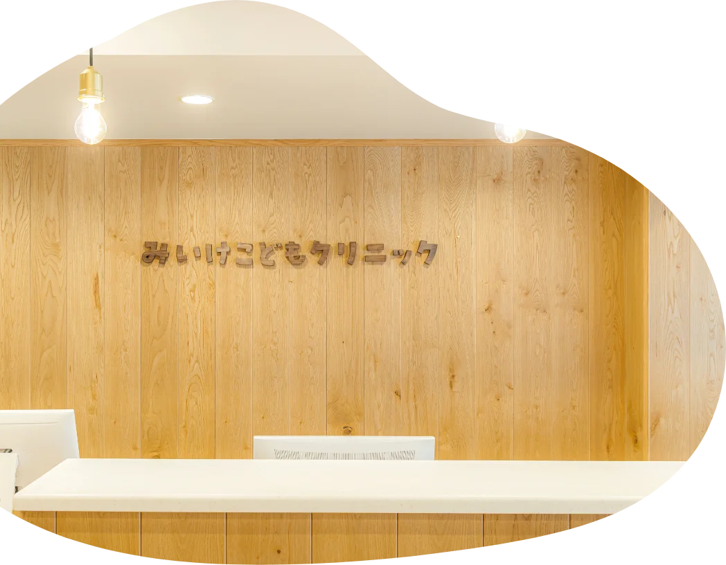 保護者に抱かれて予防接種を受ける乳児